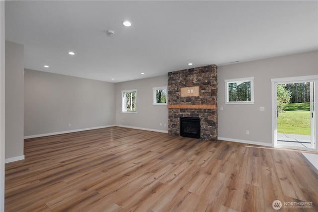 unfurnished living room with light wood-style floors, recessed lighting, a fireplace, and baseboards