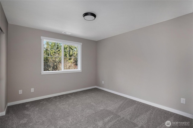 unfurnished room with carpet floors, visible vents, and baseboards