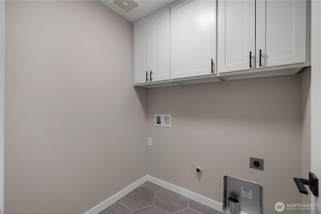 washroom featuring cabinet space, visible vents, hookup for a washing machine, hookup for an electric dryer, and dark tile patterned floors