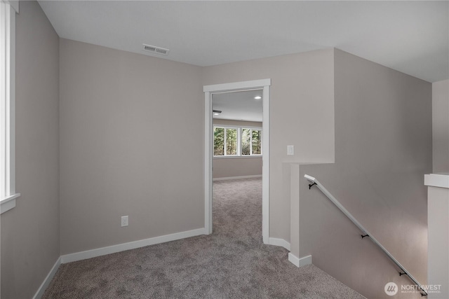 interior space with carpet floors, visible vents, and baseboards