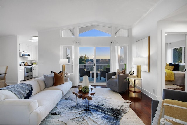 living area featuring dark wood-style floors, vaulted ceiling, ornamental molding, and baseboards