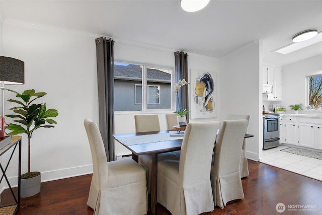 dining space featuring ornamental molding, wood finished floors, and baseboards