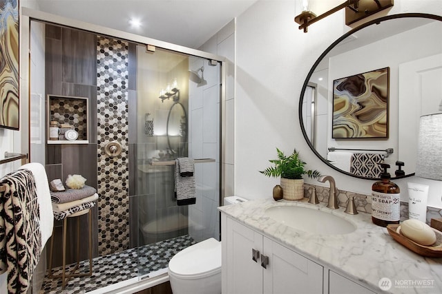 full bath featuring a shower stall, toilet, and vanity