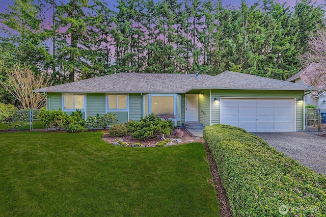 single story home with a garage, fence, a front lawn, and aphalt driveway