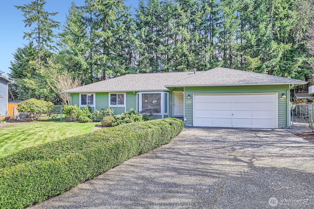 ranch-style home featuring aphalt driveway, a front lawn, a garage, and fence