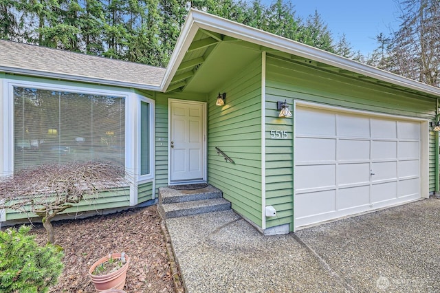 doorway to property with a garage and driveway