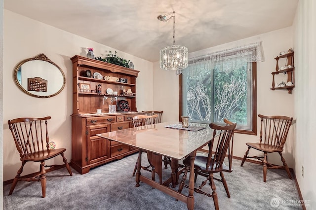 dining space featuring a notable chandelier, baseboards, and light colored carpet