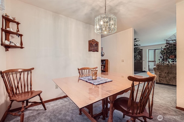 dining room featuring carpet flooring, baseboards, and an inviting chandelier