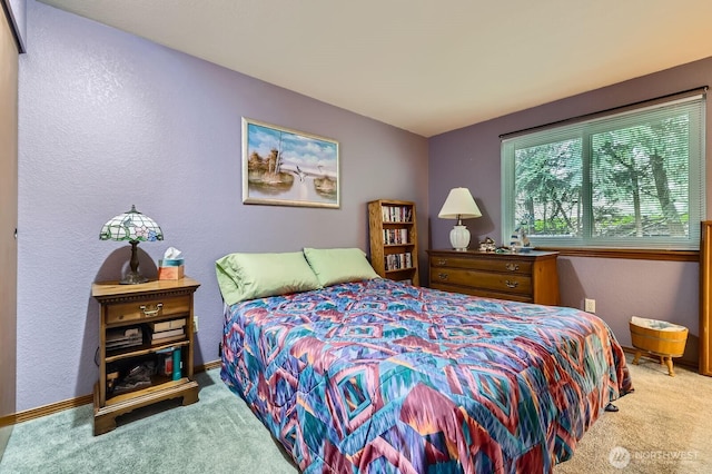 bedroom featuring carpet and a textured wall