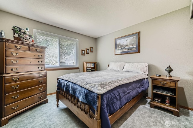 carpeted bedroom with a textured ceiling and baseboards