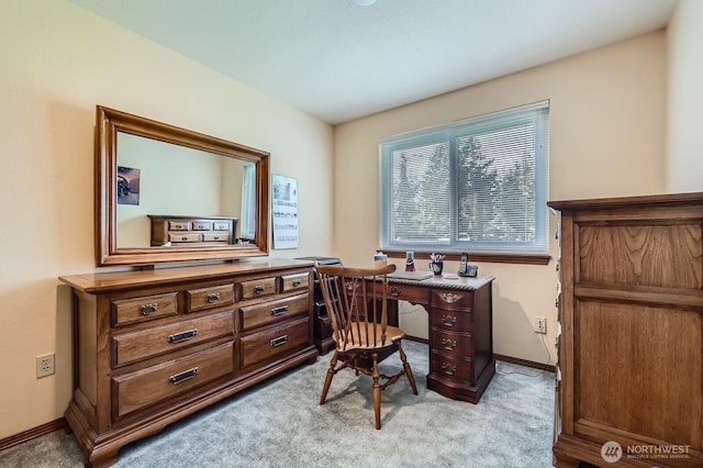 home office with baseboards and light colored carpet