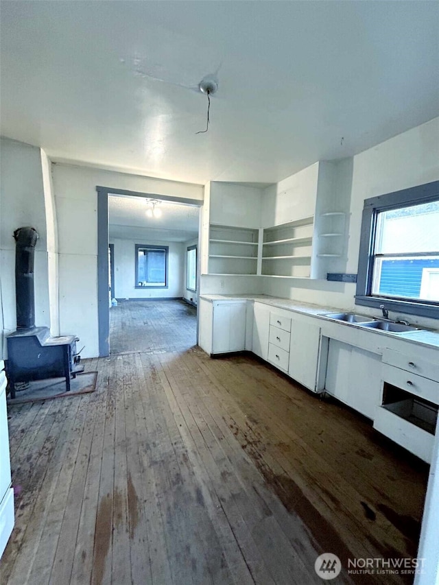 kitchen with dark wood-style flooring, white cabinetry, light countertops, and a sink