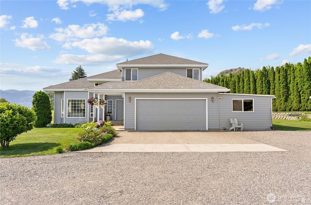 traditional-style home with an attached garage, concrete driveway, a front lawn, and a shingled roof