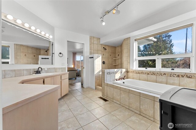 bathroom featuring tile patterned flooring, plenty of natural light, a bath, and walk in shower