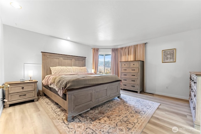 bedroom with light wood-style flooring and baseboards