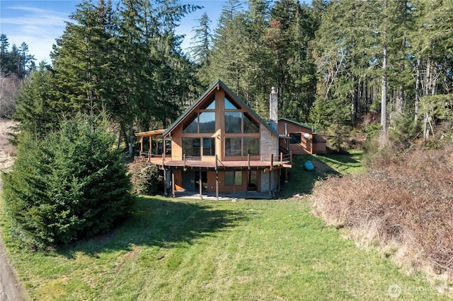 rear view of house featuring a yard and a deck