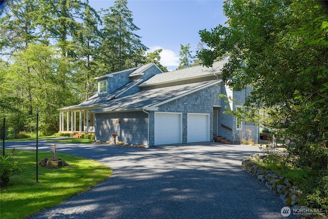 373 Eliza Rd, Lopez Island, WA 98261 - view of property exterior with asphalt driveway, an attached garage, and a shingled roof
