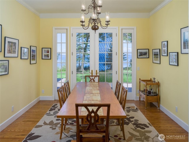 373 Eliza Rd, Lopez Island, WA 98261 - dining space with a chandelier, plenty of natural light, wood finished floors, and ornamental molding