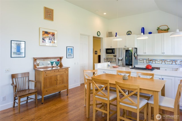 373 Eliza Rd, Lopez Island, WA 98261 - kitchen featuring stainless steel fridge with ice dispenser, white cabinets, light wood-style floors, light countertops, and high vaulted ceiling