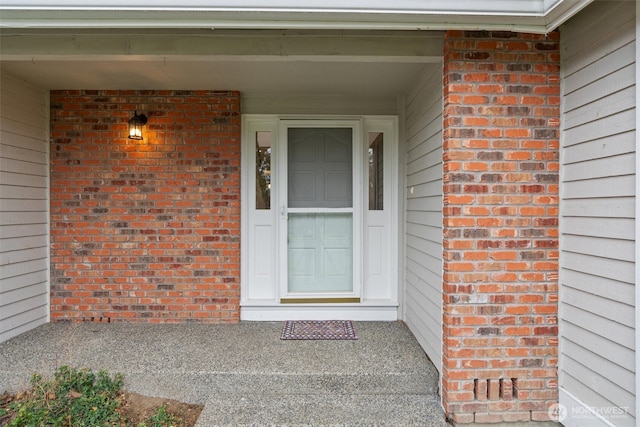 entrance to property featuring brick siding