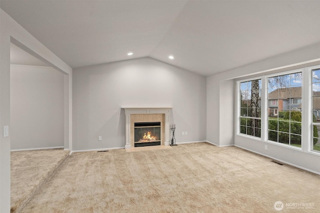 unfurnished living room featuring carpet, baseboards, recessed lighting, a tile fireplace, and vaulted ceiling