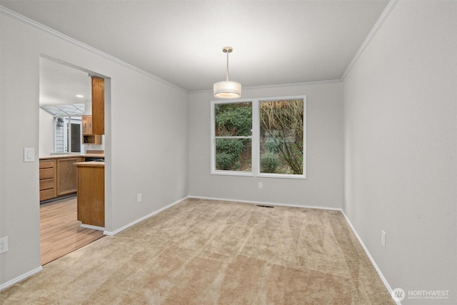 spare room featuring light carpet, visible vents, crown molding, and baseboards