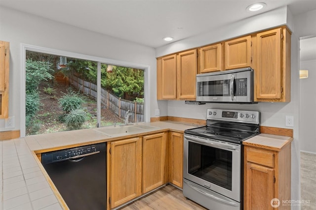 kitchen featuring light wood finished floors, recessed lighting, appliances with stainless steel finishes, and a sink