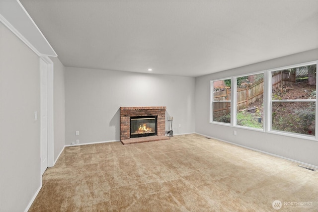 unfurnished living room featuring visible vents, baseboards, carpet flooring, recessed lighting, and a fireplace