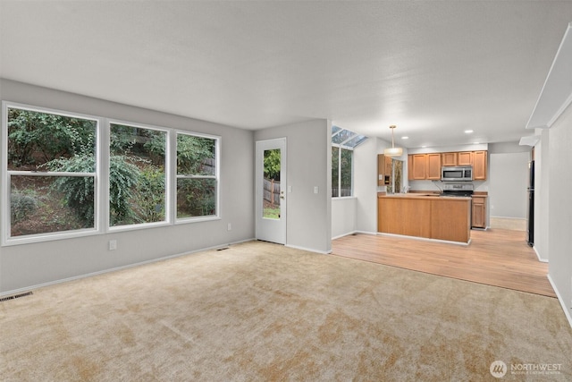 unfurnished living room with recessed lighting, visible vents, light carpet, and baseboards