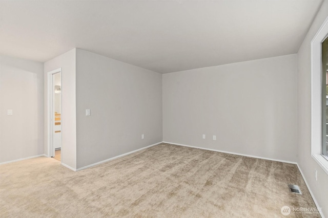 carpeted empty room featuring visible vents and baseboards