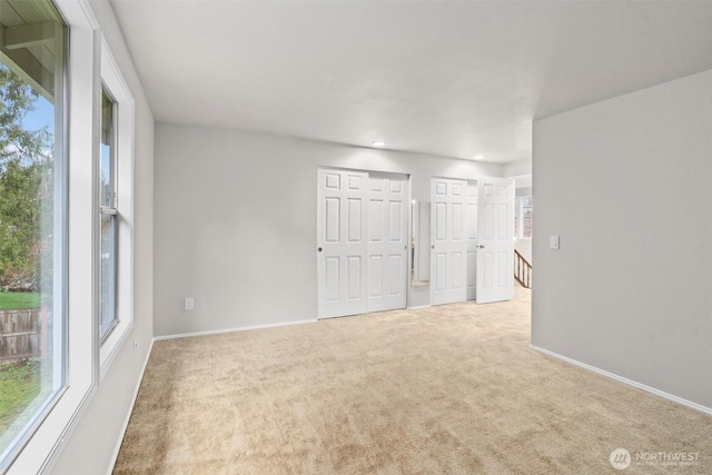 carpeted empty room featuring baseboards