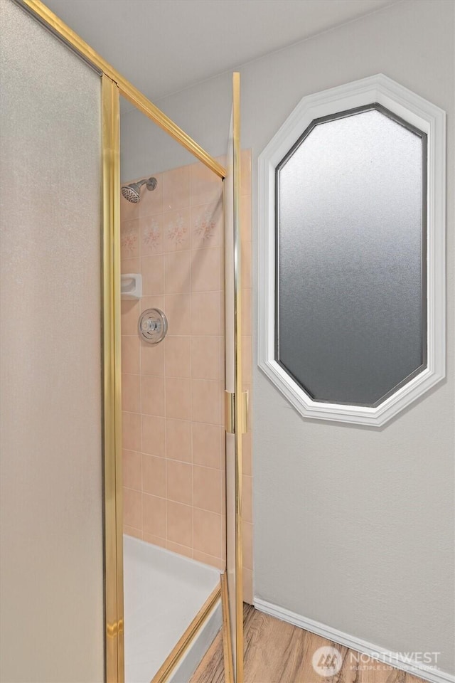 full bathroom featuring wood finished floors and a stall shower