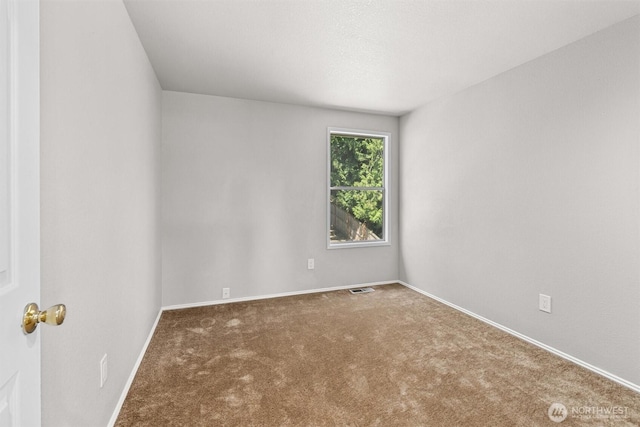 carpeted spare room featuring visible vents and baseboards