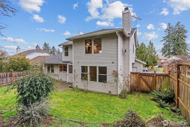 rear view of house featuring a yard, a fenced backyard, a chimney, and a patio area