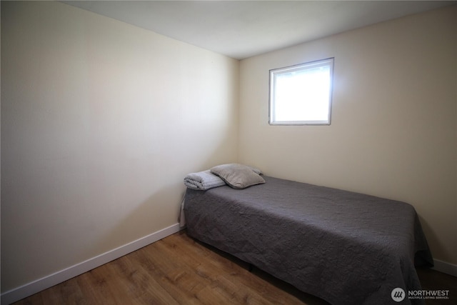 bedroom featuring baseboards and wood finished floors