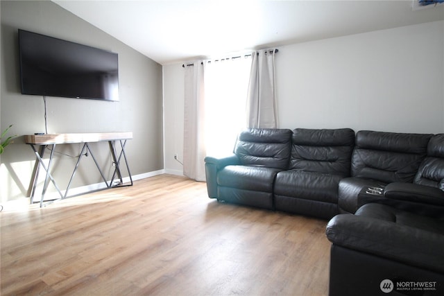 living room with lofted ceiling, baseboards, and wood finished floors