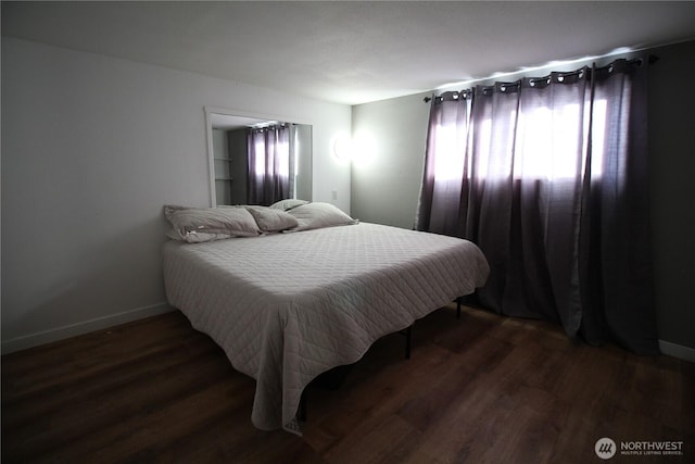 bedroom featuring baseboards and wood finished floors