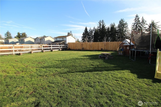 view of yard featuring a fenced backyard and a trampoline