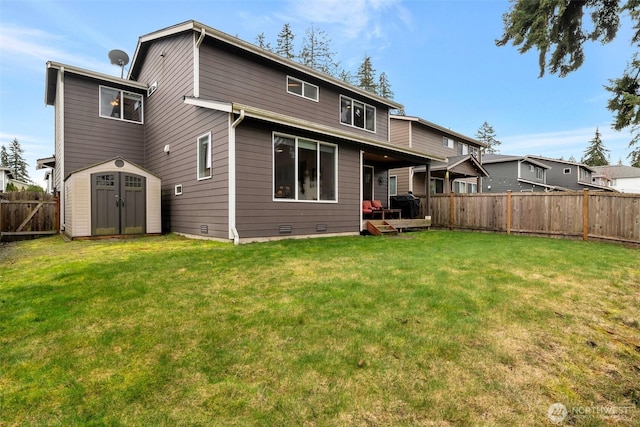 rear view of property featuring an outbuilding, a fenced backyard, a yard, a storage shed, and crawl space