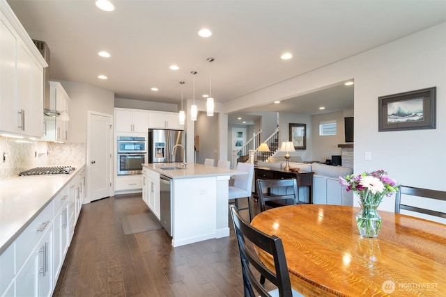 kitchen with backsplash, white cabinetry, recessed lighting, stainless steel appliances, and light countertops