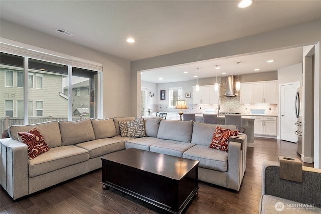 living room with dark wood-type flooring, recessed lighting, and visible vents