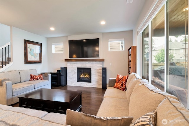 living area featuring recessed lighting, stairway, wood finished floors, and a fireplace