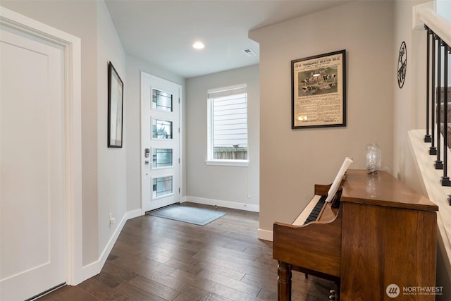 foyer with dark wood finished floors, recessed lighting, and baseboards