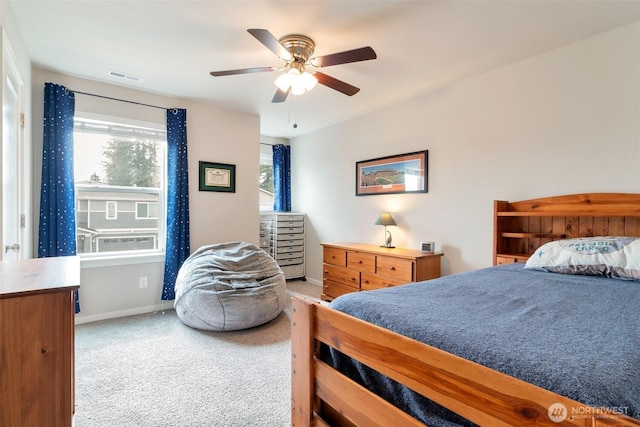 carpeted bedroom featuring a ceiling fan, baseboards, and visible vents