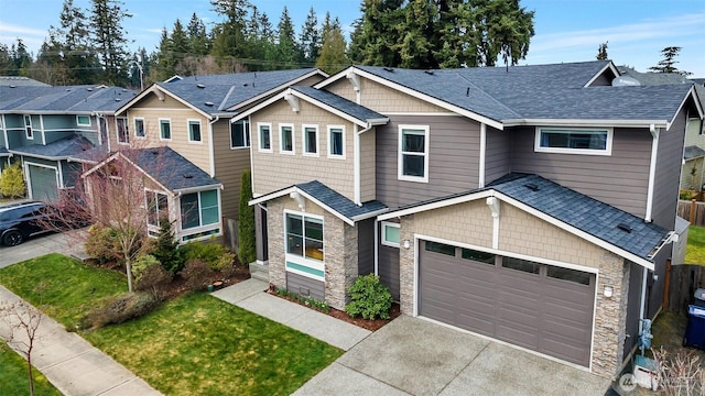 view of front facade featuring stone siding, a residential view, roof with shingles, and concrete driveway