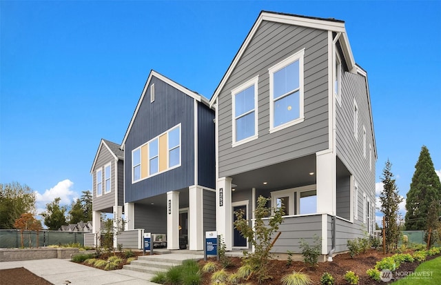 contemporary home featuring fence and board and batten siding