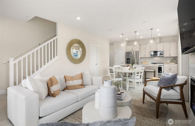 living area featuring stairs and recessed lighting