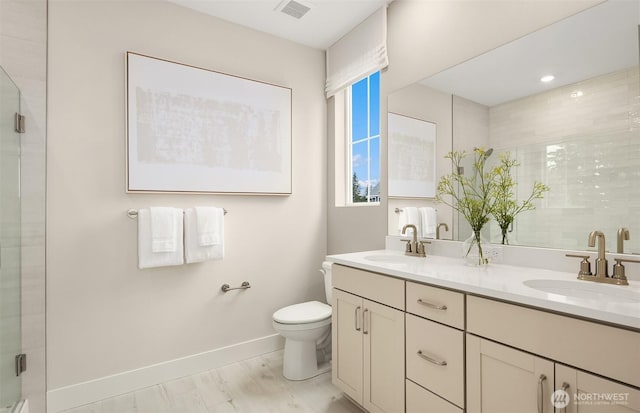 full bathroom with toilet, baseboards, visible vents, and a sink