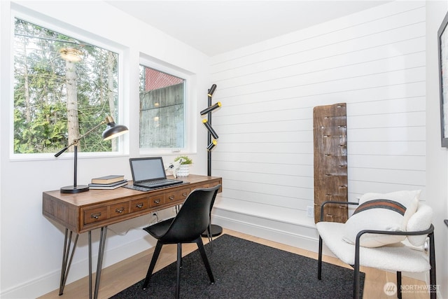 home office featuring baseboards, wood finished floors, and wood walls