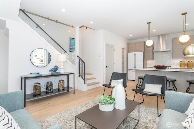 living room featuring recessed lighting, stairway, and light wood-style flooring